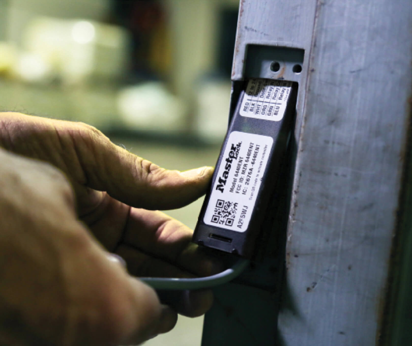 Technician installing a Master Lock® Bluetooth® Door Controller.