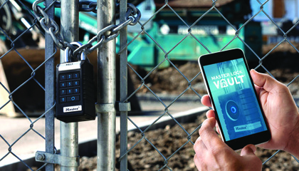 Master Lock Proseries padlock on gate with hand holding a phone displaying the Master Lock Vault app